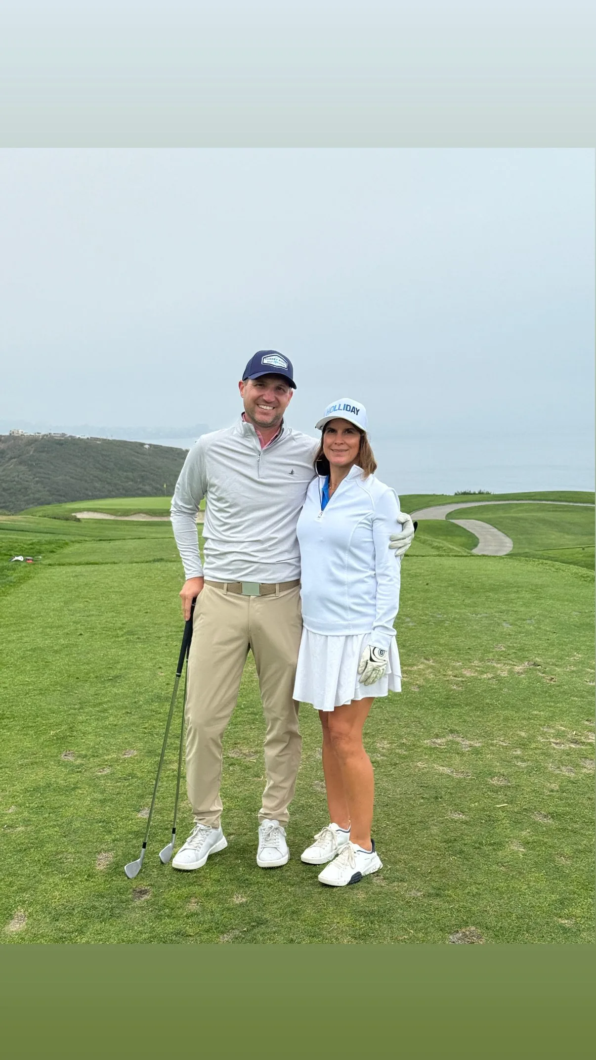 A couple standing together on a coastal golf course