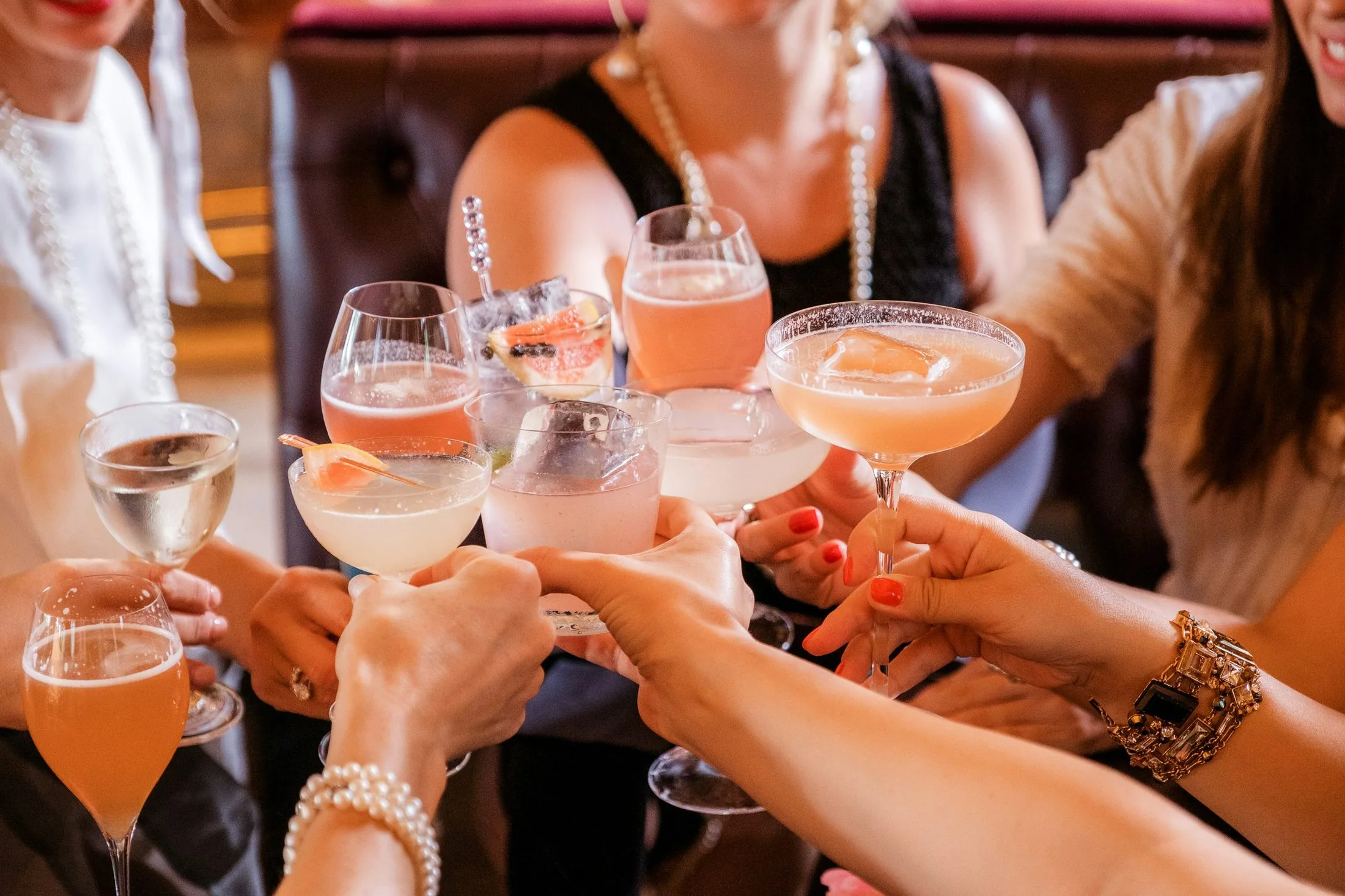 Women raising cocktail glasses in a celebratory toast