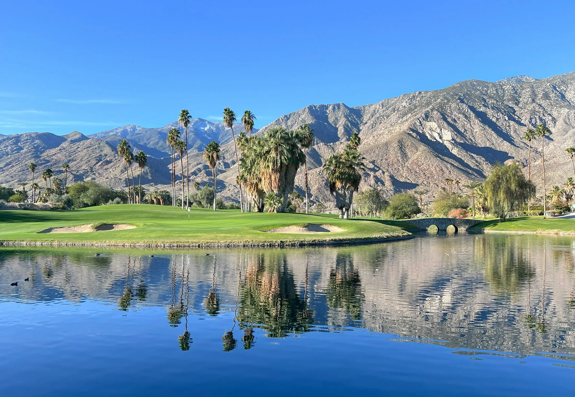 A desert resort golf course set against rugged mountains